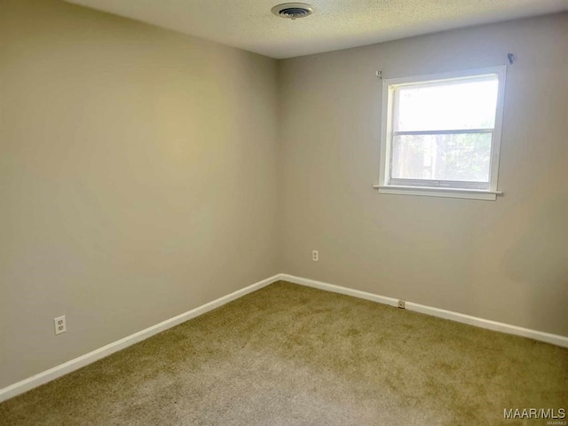 carpeted spare room featuring a textured ceiling