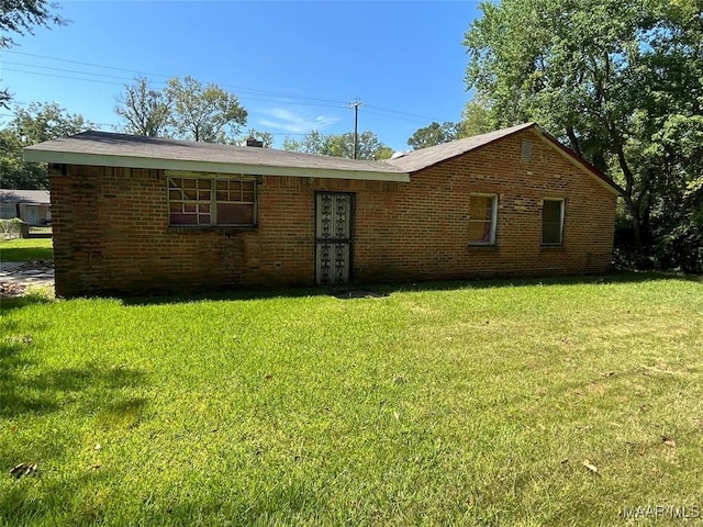 rear view of house featuring a yard