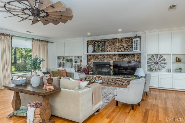 living room with a fireplace, light hardwood / wood-style flooring, ceiling fan, and crown molding