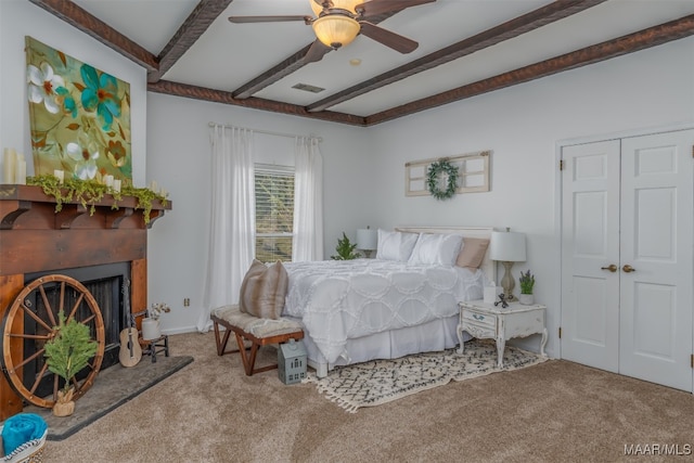 bedroom featuring beamed ceiling, light carpet, and ceiling fan