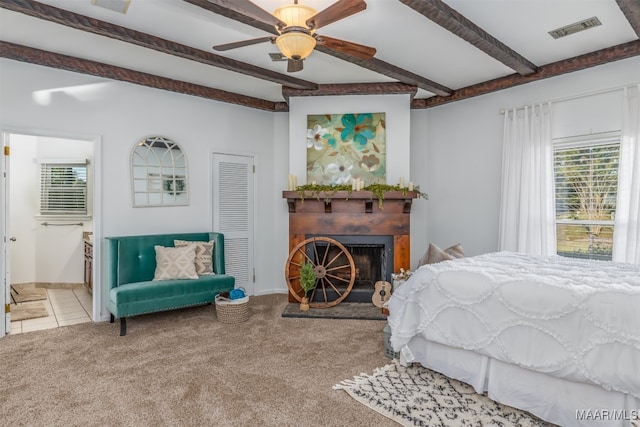 carpeted bedroom featuring ceiling fan and beamed ceiling