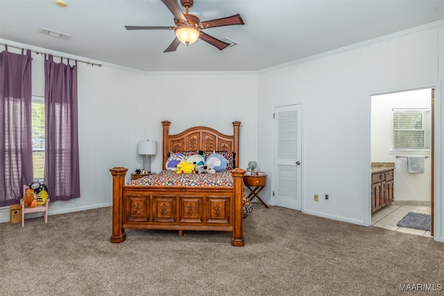 bedroom featuring light colored carpet, ceiling fan, ensuite bath, and ornamental molding