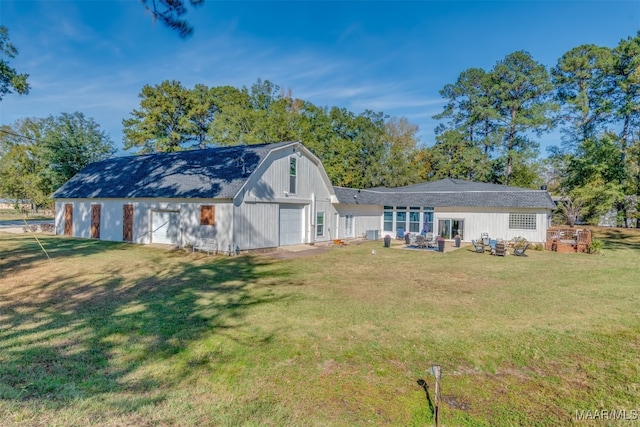 back of house with a garage and a yard