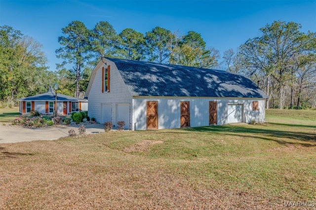 view of outbuilding with a garage and a lawn