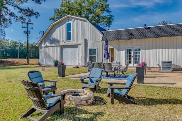 rear view of house featuring a patio, an outdoor fire pit, central AC, and a yard