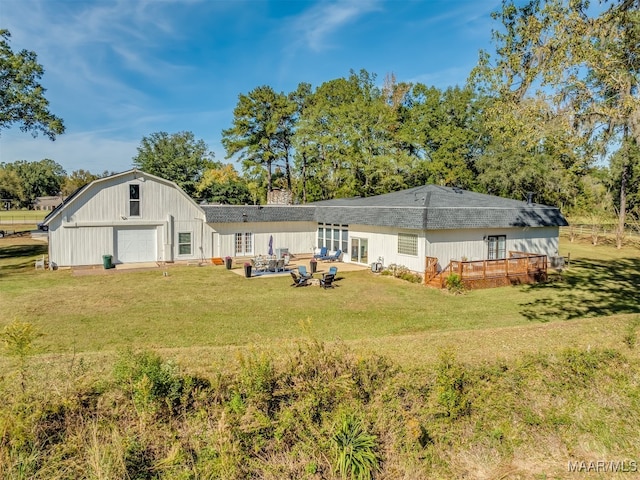 back of property with a patio area, a garage, a yard, and a wooden deck