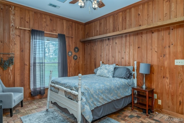 bedroom with wood walls, ceiling fan, and ornamental molding