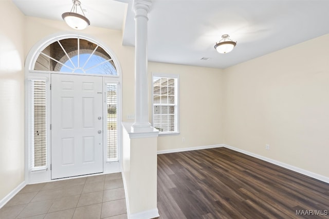 entrance foyer featuring ornate columns and wood-type flooring