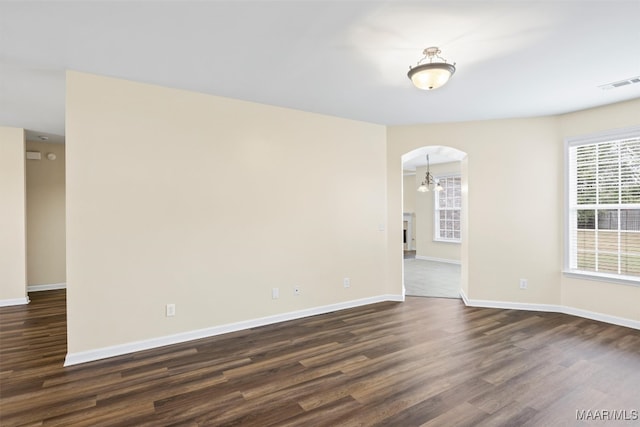 unfurnished room featuring dark hardwood / wood-style flooring and a notable chandelier