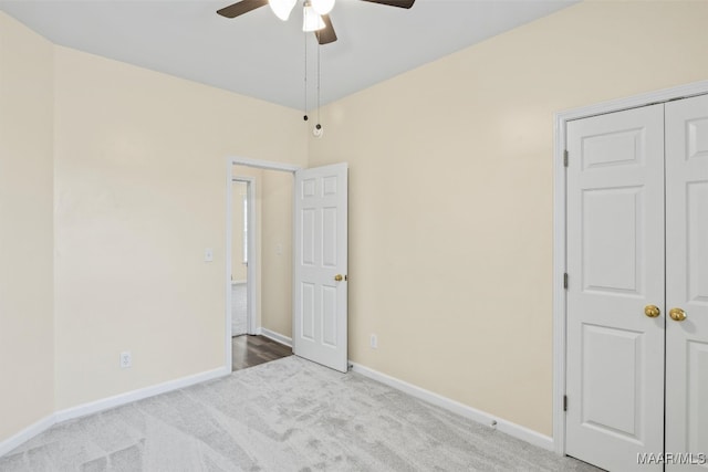 unfurnished bedroom featuring ceiling fan, a closet, and light colored carpet