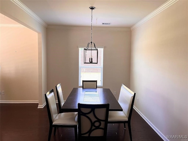 dining area with dark wood-type flooring and crown molding