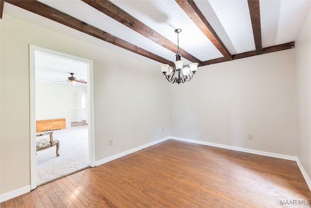 spare room with hardwood / wood-style flooring, ceiling fan with notable chandelier, and beam ceiling