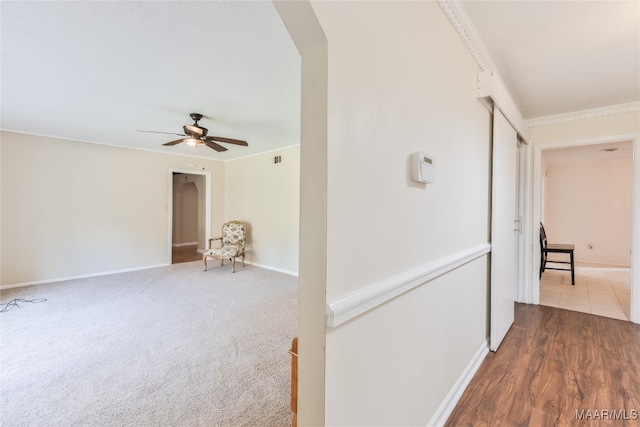 corridor with ornamental molding and hardwood / wood-style flooring