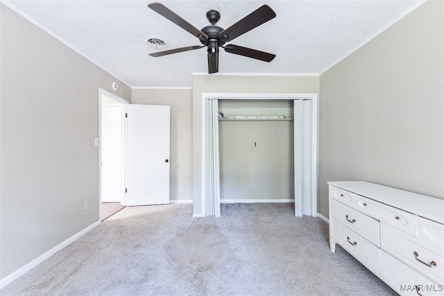 unfurnished bedroom with ceiling fan, a textured ceiling, a closet, and light colored carpet