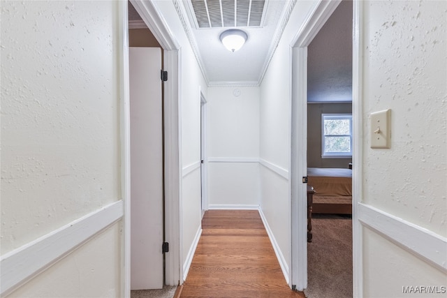 hall featuring hardwood / wood-style flooring and crown molding