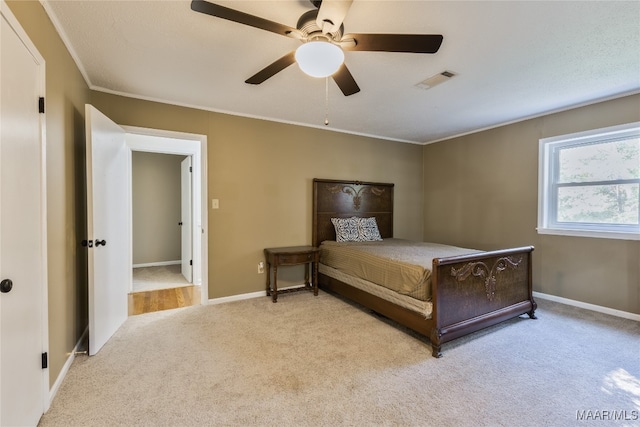 carpeted bedroom featuring ceiling fan and crown molding