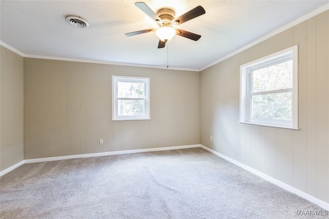 carpeted spare room with ornamental molding, a textured ceiling, and ceiling fan