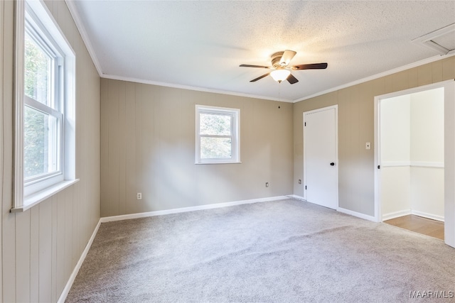 carpeted empty room featuring ornamental molding, a textured ceiling, and ceiling fan