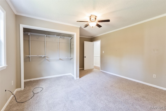 unfurnished bedroom with a closet, crown molding, a textured ceiling, light carpet, and ceiling fan