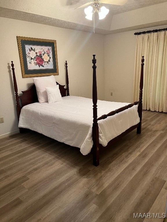 bedroom featuring hardwood / wood-style floors, ceiling fan, and a textured ceiling