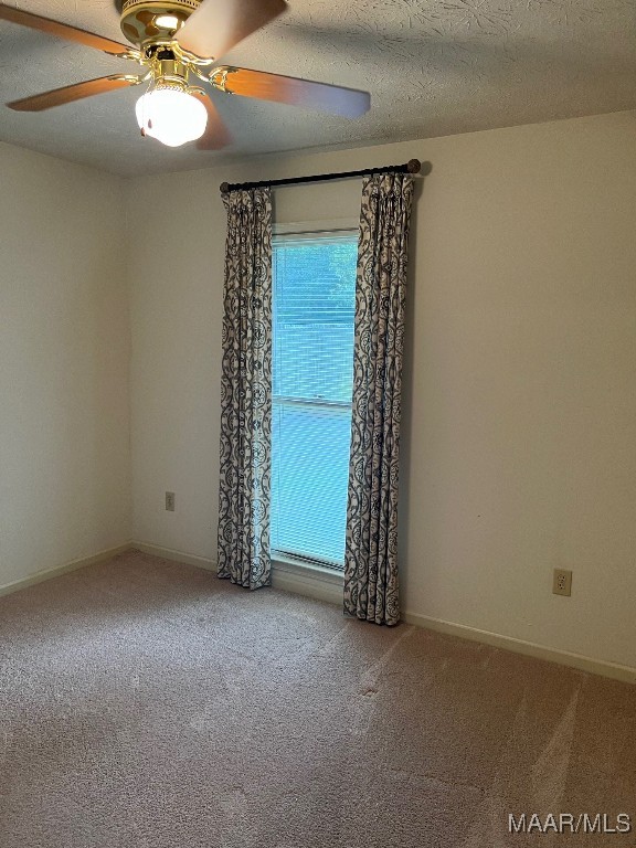 unfurnished room with a textured ceiling, ceiling fan, and carpet floors