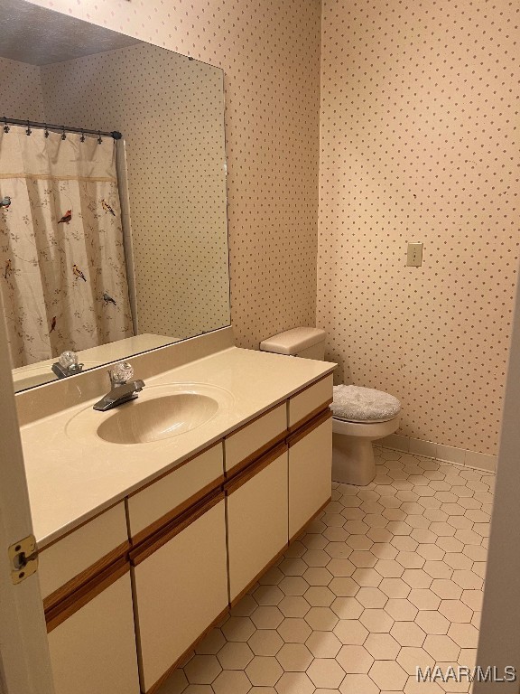 bathroom featuring a shower with shower curtain, tile patterned floors, vanity, and toilet