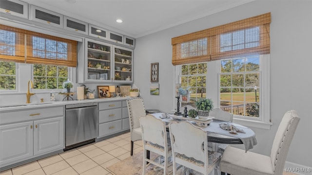 kitchen with white cabinetry, stainless steel dishwasher, sink, and light tile patterned flooring