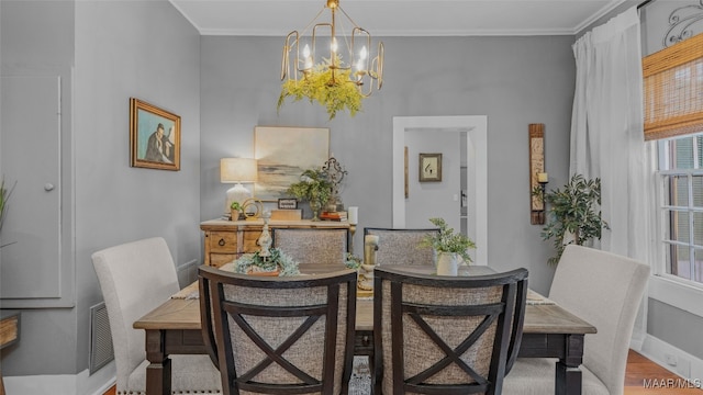 dining room featuring a chandelier, light hardwood / wood-style flooring, and crown molding