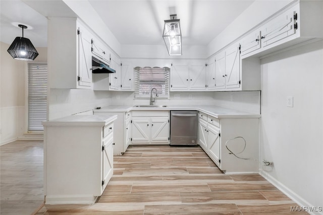 kitchen with light hardwood / wood-style floors, white cabinets, sink, stainless steel dishwasher, and decorative light fixtures