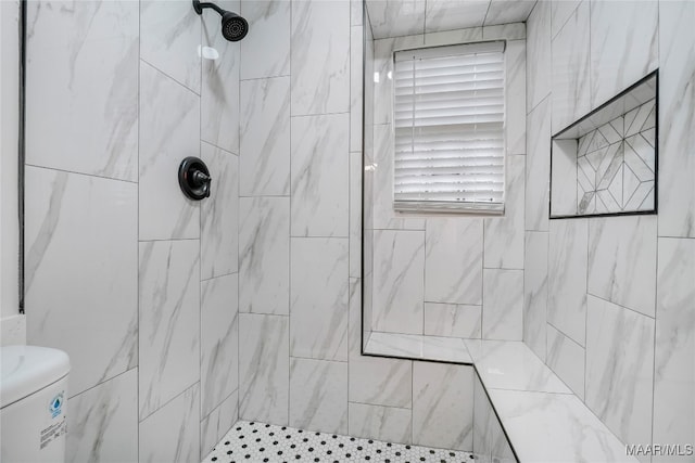 bathroom featuring toilet and a tile shower