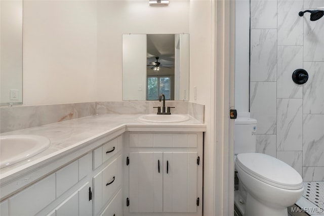 bathroom with ceiling fan, vanity, toilet, and a tile shower