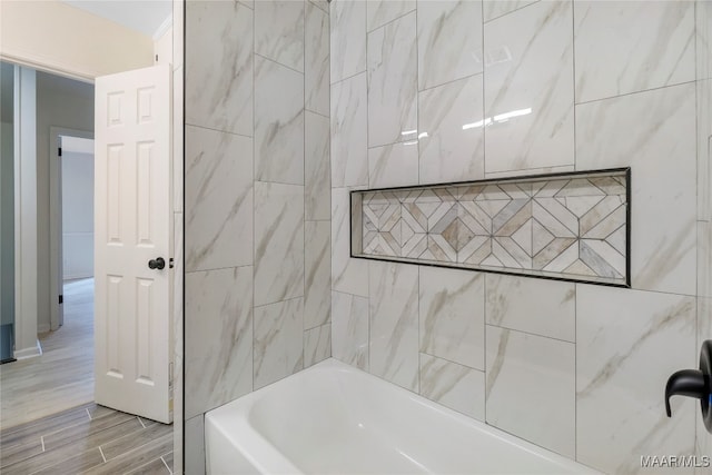 bathroom with tiled shower / bath combo and tile walls