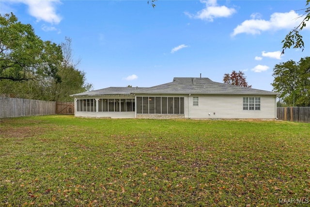 rear view of house with a sunroom and a lawn