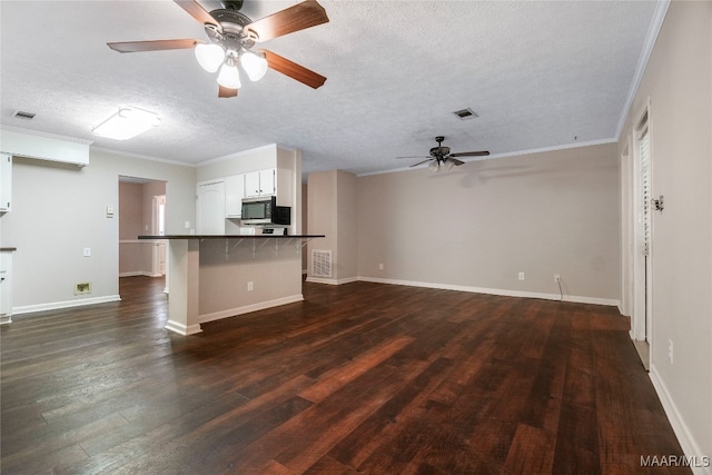 unfurnished living room featuring dark wood-type flooring, ceiling fan, a textured ceiling, and ornamental molding