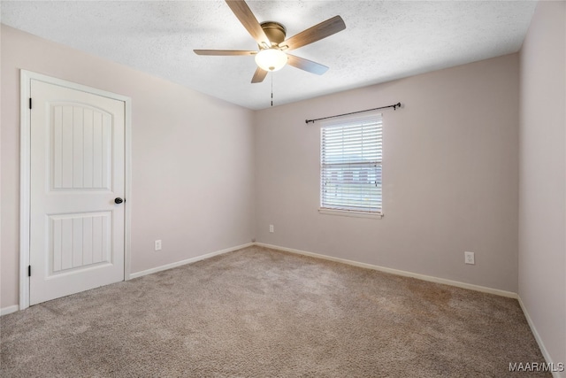 carpeted spare room with a textured ceiling and ceiling fan