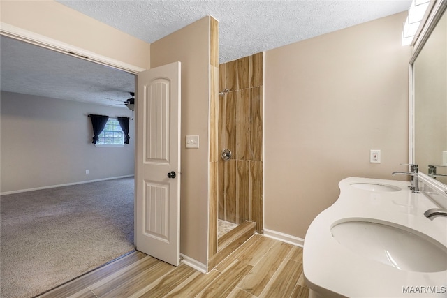 bathroom featuring hardwood / wood-style floors, walk in shower, ceiling fan, and a textured ceiling