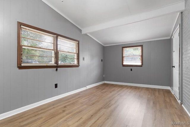 empty room with vaulted ceiling with beams, light hardwood / wood-style flooring, and ornamental molding