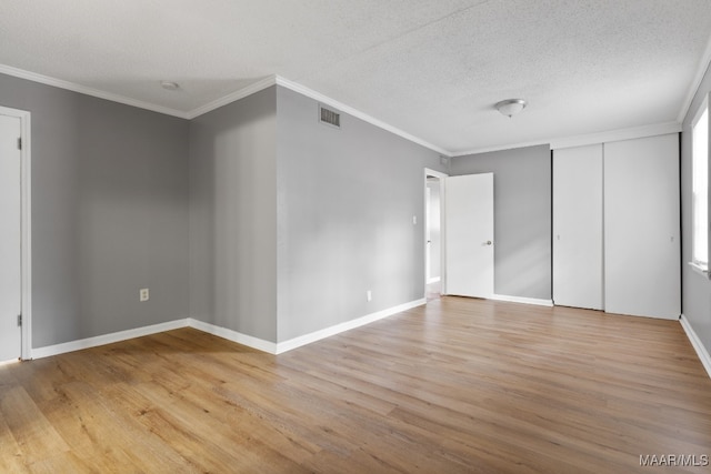 unfurnished bedroom with a closet, crown molding, hardwood / wood-style floors, and a textured ceiling