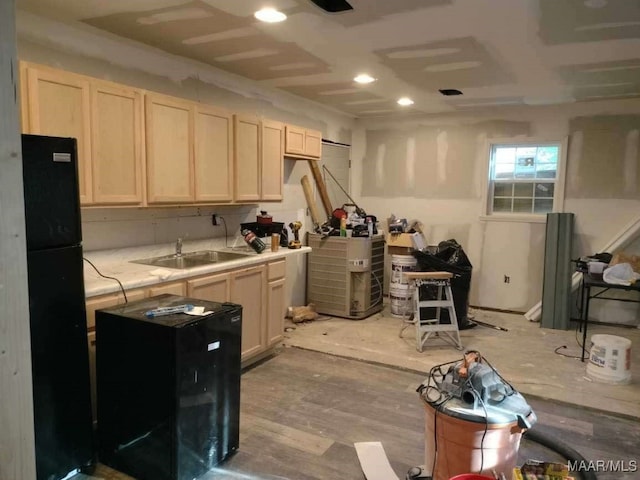 kitchen with light wood-type flooring, sink, and black refrigerator