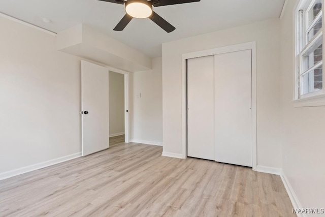 unfurnished bedroom with ceiling fan, a closet, and light wood-type flooring