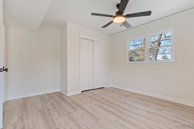 unfurnished bedroom featuring light hardwood / wood-style flooring, a closet, and ceiling fan