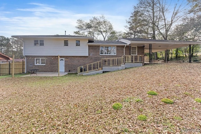 rear view of property with a wooden deck, a yard, and a patio area