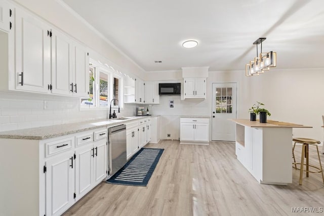 kitchen featuring hanging light fixtures, black microwave, dishwasher, decorative backsplash, and white cabinets