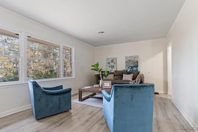 living room with crown molding and light hardwood / wood-style flooring