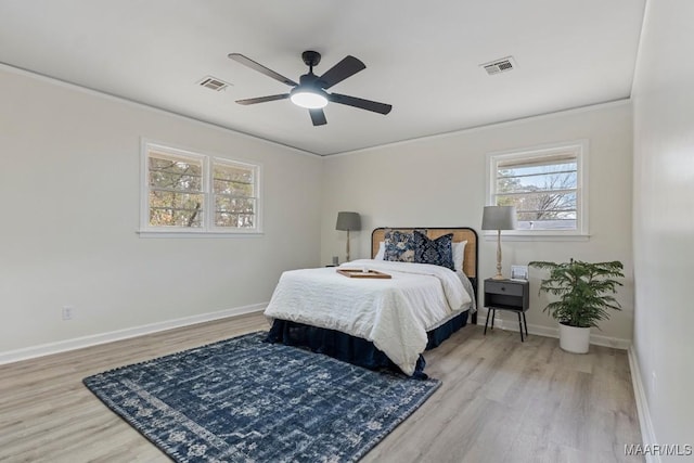 bedroom with ceiling fan, ornamental molding, and light hardwood / wood-style flooring