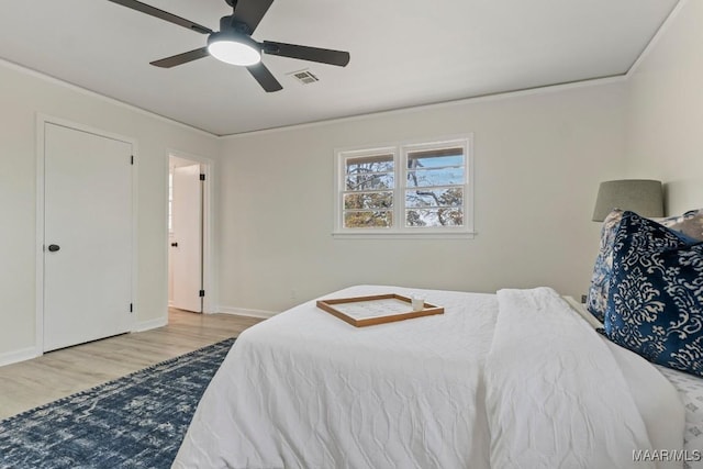 bedroom with crown molding, ceiling fan, and light hardwood / wood-style floors