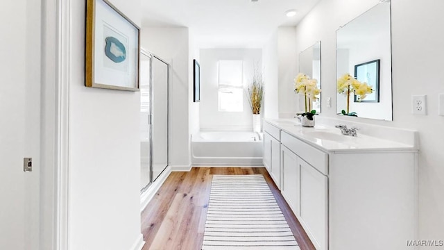 bathroom with independent shower and bath, vanity, and hardwood / wood-style flooring