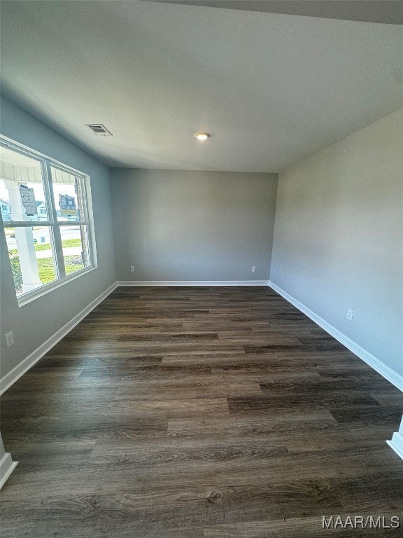 unfurnished room with dark wood-type flooring