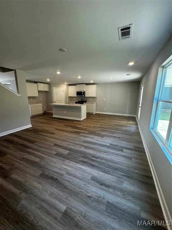 unfurnished living room with dark hardwood / wood-style flooring and sink