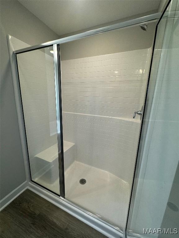 bathroom with hardwood / wood-style floors and walk in shower